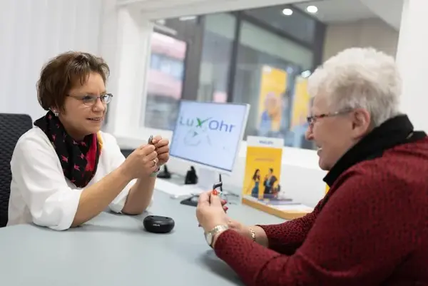 Hörgeräteakustikerin berät Seniorin zu modernen Hörgeräten im Fachgeschäft.